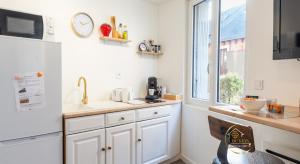 a kitchen with white cabinets and a window at Escapade studio centre ville Rodez in Rodez