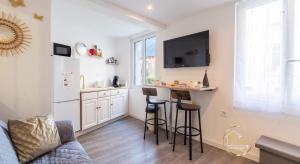 a living room with a kitchen and a bar with stools at Escapade studio centre ville Rodez in Rodez