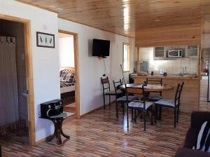 a kitchen and dining room with a table and chairs at Cabañas Vista Parapentes in Maitencillo