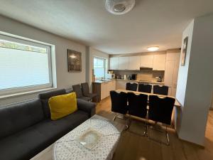 a living room with a couch and a kitchen at ISIS---Ferienwohnung in Steinach am Brenner