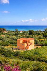 a house in a field with the ocean in the background at Rodanthy I in Katelios