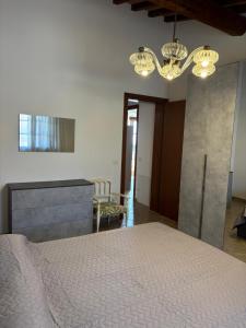 a bedroom with a white bed and a chandelier at Mary's House in Guardistallo