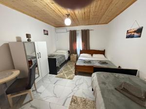 a bedroom with two beds and a desk and a sink at Xhoen guesthouse in Shkodër
