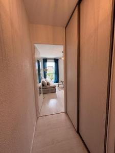 a hallway with a mirror and a couch in a room at Studio cosy - Proche centre Dijon in Dijon