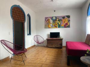 a living room with two chairs and a couch at Casa Malinalli in Zihuatanejo