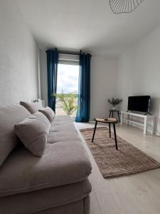 a living room with a couch and a table at Studio cosy - Proche centre Dijon in Dijon