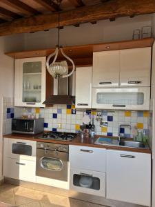 a kitchen with white cabinets and a stove top oven at Mary's House in Guardistallo +13 photos