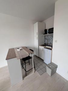 a small kitchen with a table and a counter top at Studio cosy - Proche centre Dijon in Dijon +11 photos