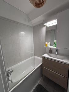 a white bathroom with a tub and a sink at Studio cosy - Proche centre Dijon in Dijon
