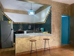 a kitchen with two stools at a counter with a sink at Casa Malinalli in Zihuatanejo