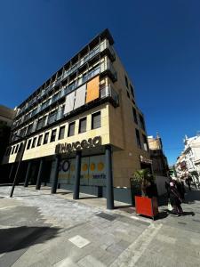 a building on a street with people walking in front of it at AT home Santo Domingo in Guadalajara