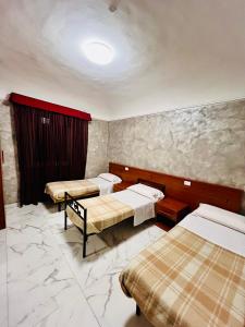 a room with three beds in a room with marble walls at Beauty Holidays in Rome