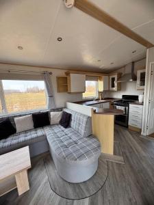 a living room with a couch and a kitchen at FarmaKolonia2 in Zabiele