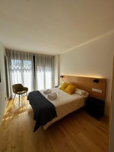 a bedroom with a large bed and a chair at AT home Santo Domingo in Guadalajara