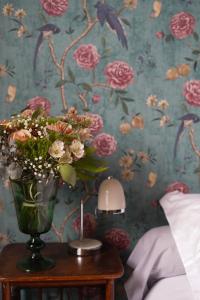 a vase of flowers on a table in a bedroom at La Maison Saint Aignan in Saint-Aignan