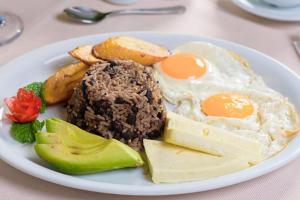 a plate of food with eggs and cheese and vegetables at Casa de playa MC in Quepos