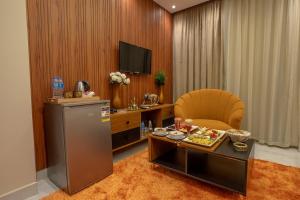 a living room with a table and a chair and a television at The Muse Luxury View Hotel in Cairo