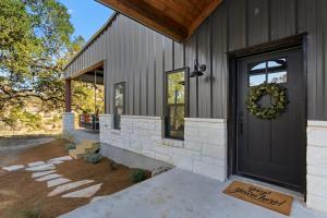a front door of a house with a wreath on it at Barndo on the Blanco in Wimberley