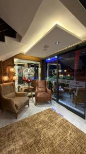 a living room with two chairs and a table at Dostlar Hotel in Mersin