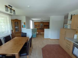a kitchen with a wooden table and a dining room at Große Ferienwohnung im Rosental ideal für 4 bis 6 Personen mit Balkon und Garten in Maria Elend