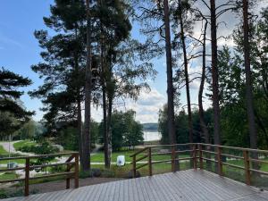 a wooden deck with trees and a view of a lake at Vuohensaari, Rantatalo 3 in Salo +3 photos