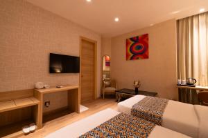 a hotel room with two beds and a flat screen tv at Hotel Bluestone Prime Nehru Place by The Cosy hotels in New Delhi +72 photos