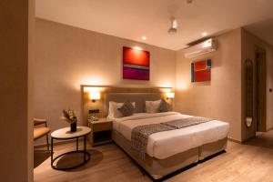 a hotel room with a bed and a table at Hotel Bluestone Prime Nehru Place by The Cosy hotels in New Delhi