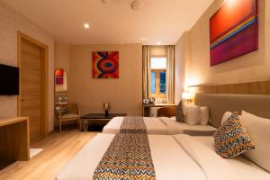 a hotel room with two beds and a television at Hotel Bluestone Prime Nehru Place by The Cosy hotels in New Delhi