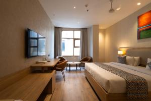 a hotel room with a bed and a desk at Hotel Bluestone Prime Nehru Place by The Cosy hotels in New Delhi
