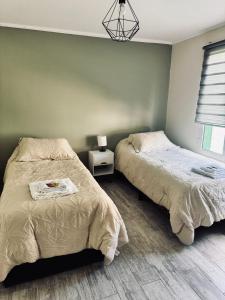 a bedroom with two beds and a chandelier at Brumas Patagónicas in El Chalten