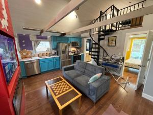 a living room with a couch and a spiral staircase at Wally’s Matchbox |New|Hot Tub|Fire Pit|Close 2 All in Hawley