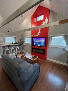 a living room with a couch and a tv at Wally’s Matchbox |New|Hot Tub|Fire Pit|Close 2 All in Hawley
