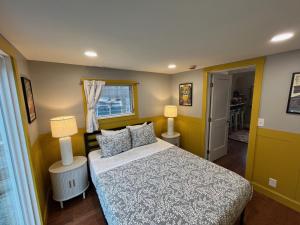 a small bedroom with a bed and two lamps at Wally’s Matchbox |New|Hot Tub|Fire Pit|Close 2 All in Hawley