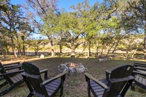 two chairs around a fire pit in a park at Barndo on the Blanco in Wimberley