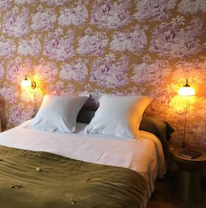 a bedroom with a bed with pink floral wallpaper at La Maison Saint Aignan in Saint-Aignan