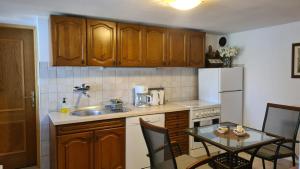 a kitchen with wooden cabinets and a table with chairs at Apartman Karla in Mostar