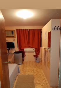 a room with a bed and a red curtain at Triple K Complex in Kelly Village +3 photos