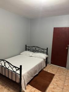 a bedroom with a bed in a white room at Triple K Complex in Kelly Village