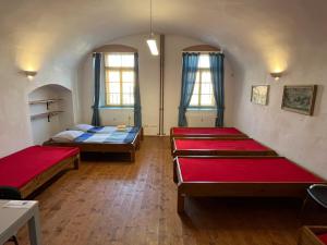 a room with three beds and two windows at Artillery Barracks Accommodation in Terezín