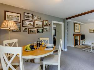a dining room with a wooden table and chairs at 1 Bed in Brockenhurst oc-78767 in Beaulieu +13 photos