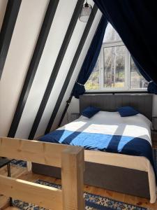 a bedroom with a bed and a window at NOOR A-frame Sibiu in Gura Râului