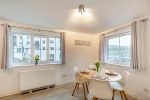 a dining room with a table and chairs and two windows at 2 Bed in Woolacombe oc-bsnug in Woolacombe +9 photos