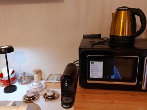 a microwave sitting on a counter with a coffee pot on it at Angy's House in Verona