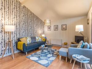 a living room with a blue couch and a table at 1 Bed in Brockenhurst oc-78005 in Beaulieu
