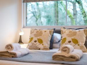 a bed with towels on it with a window at 1 Bed in Brockenhurst oc-78005 in Beaulieu