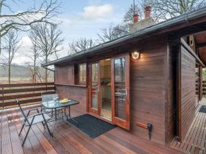 a small wooden cabin with a table and a patio at 1 Bed in Brockenhurst oc-78005 in Beaulieu