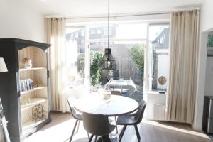 a dining room with a table and chairs and a large window at Next To Sea in Vlissingen