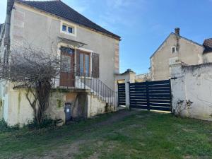 an old house with a gate and a fence at Gite la fontaine dargent in Aisy-sur-Armançon