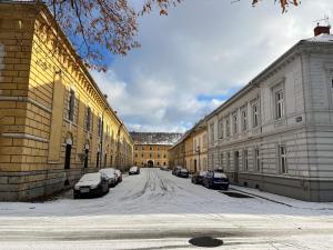 a street with cars parked on the side of a building at Artillery Barracks Accommodation in Terezín