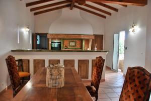 a dining room with a wooden table and chairs at Villa A Macchia, piscine et vue sur Bonifacio in Bonifacio